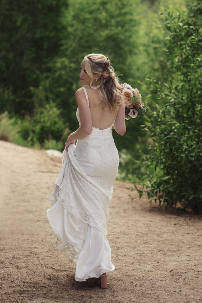 Wedding and Elopement Photographer, bride walking down a dirt road with her bouquet