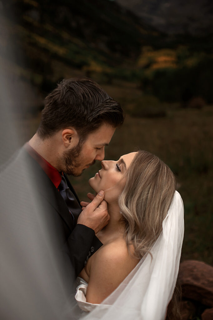 Elopement Photographer, groom tipping bride's chin up for a kiss