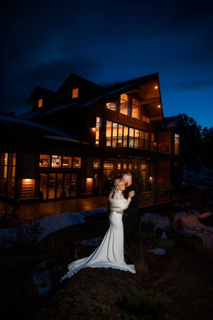 Wedding and Elopement Photography, bride and groom standing outside of lavish cabin in the evening