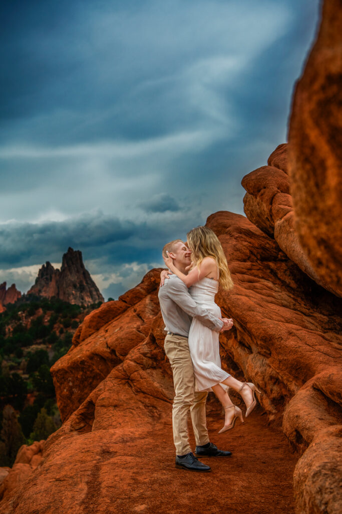 Wedding and Elopement Photography, Man and woman standing on large red rock outcrop holding each other